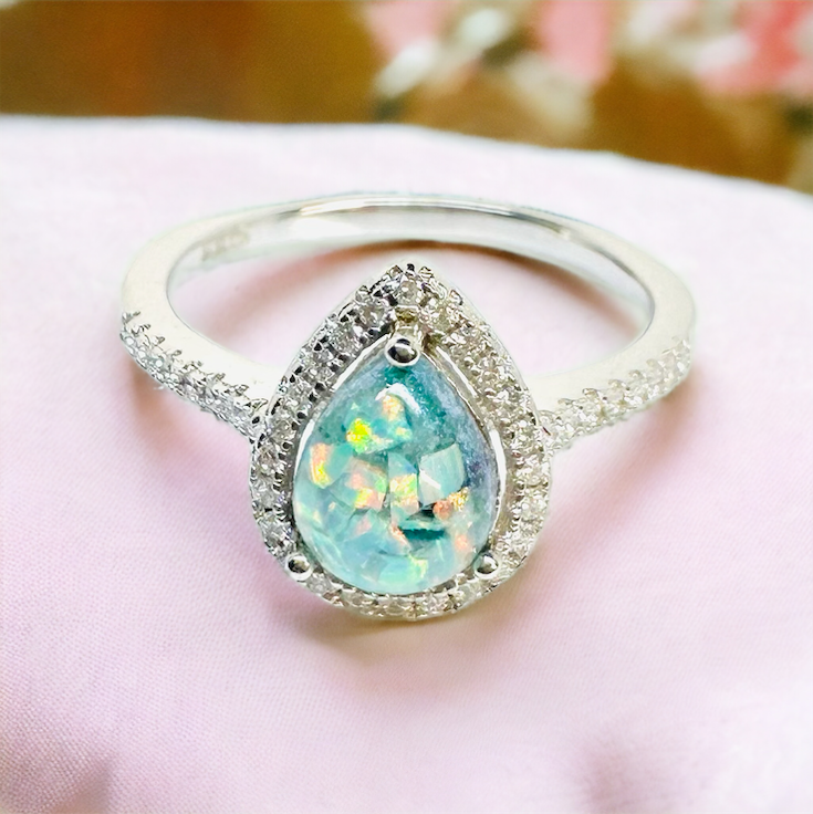 Close-up view of the Precious Drop Halo Pear Ring in Sterling Silver, showcasing the vibrant Neptune crushed opal stone, surrounded by a halo of cz stones, a tribute to cherished moments.