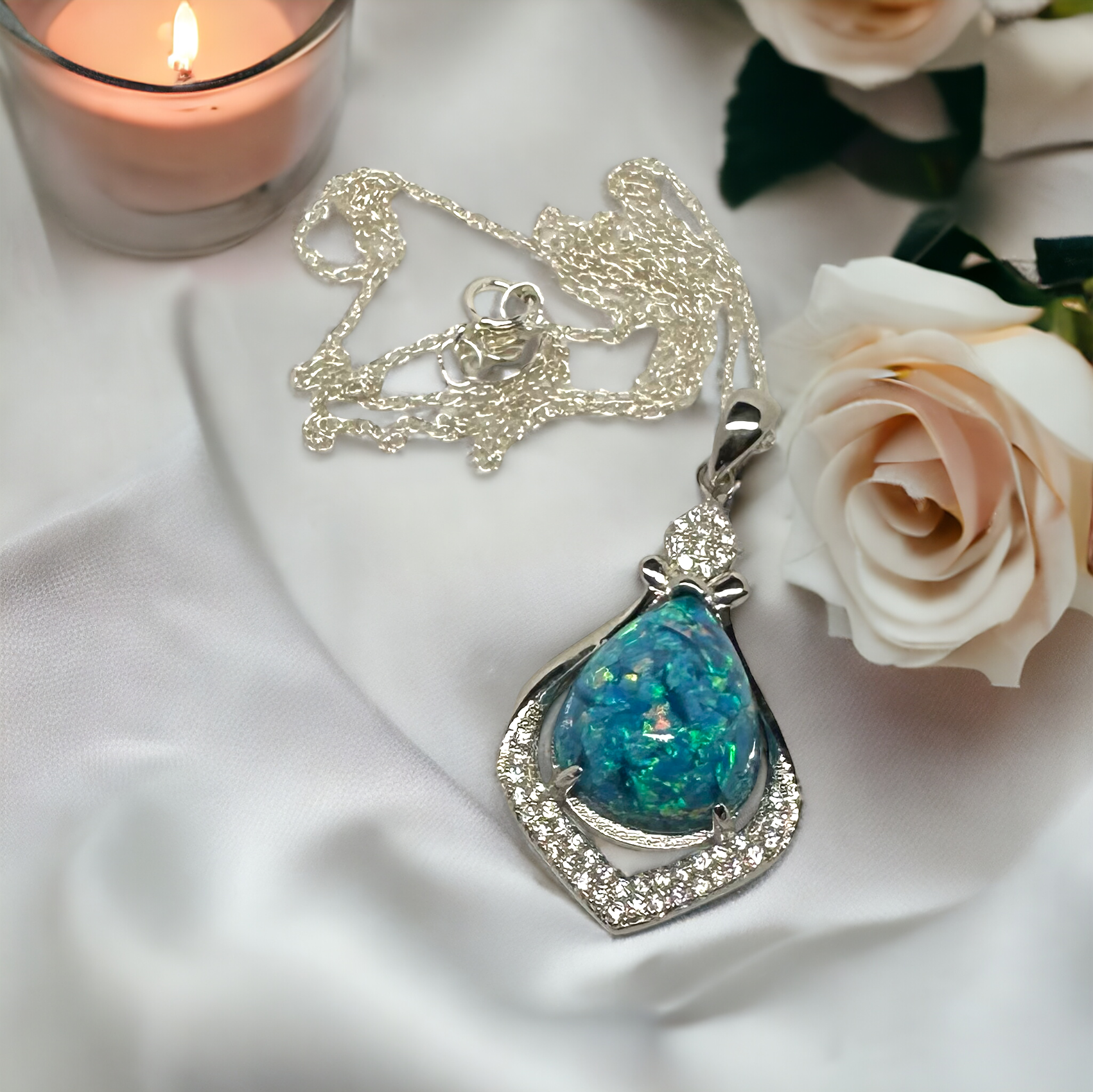 Crystal Drop pear-shaped pendant with blue crushed opal stone in sterling silver setting, laid out on a table showing the full chain, illustrating the detailed craftsmanship of the keepsake necklace.