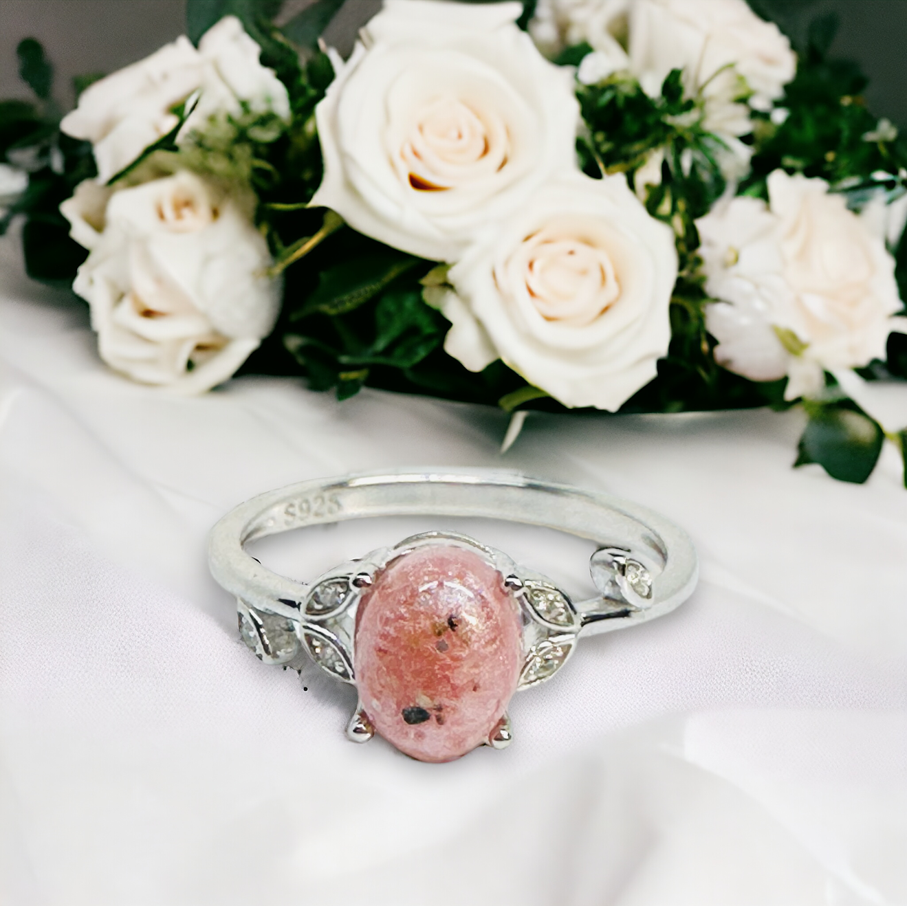 Close-up view of the Flora Petite Floral Ring in Silver, featuring a light pink cremation stone with visible ash, nestled among cz leaves, a delicate tribute to cherished moments.