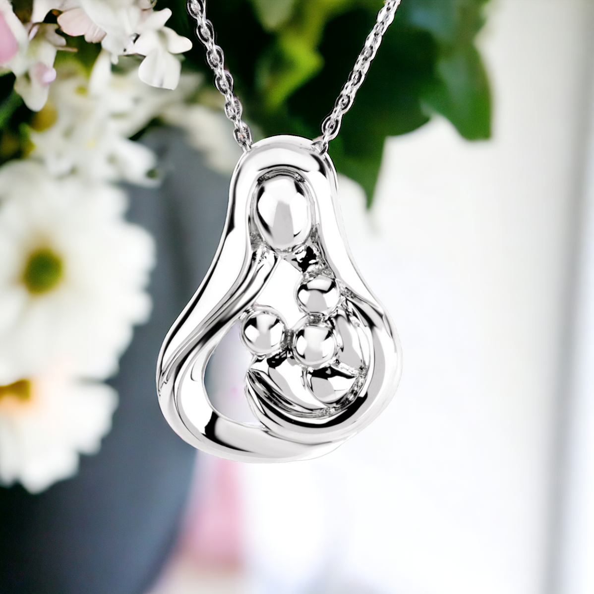 Detailed view of a sterling silver pendant showing a mother and 3 children in an embrace, capturing the essence of her protective love.