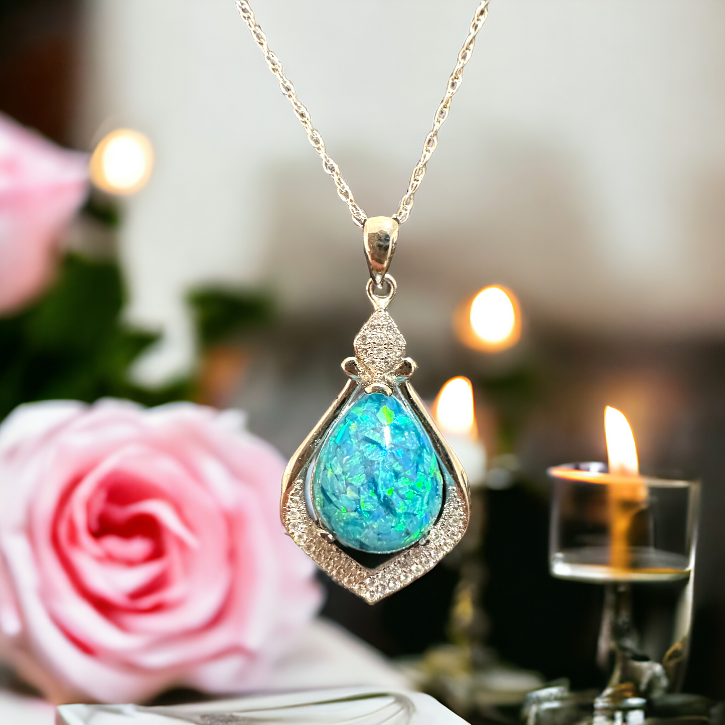 Close-up of Crystal Drop necklace in sterling silver, featuring a pear-shaped blue crushed opal cremation stone, elegantly hanging to showcase its vibrant color and unique memorial jewelry design.