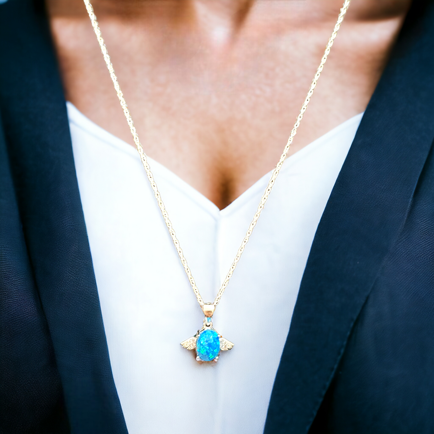 Angel's Touch angel wing necklace in silver, worn by a model, featuring an ocean blue cremation ash crushed opal stone, highlighting the beauty and significance of carrying loved ones close.