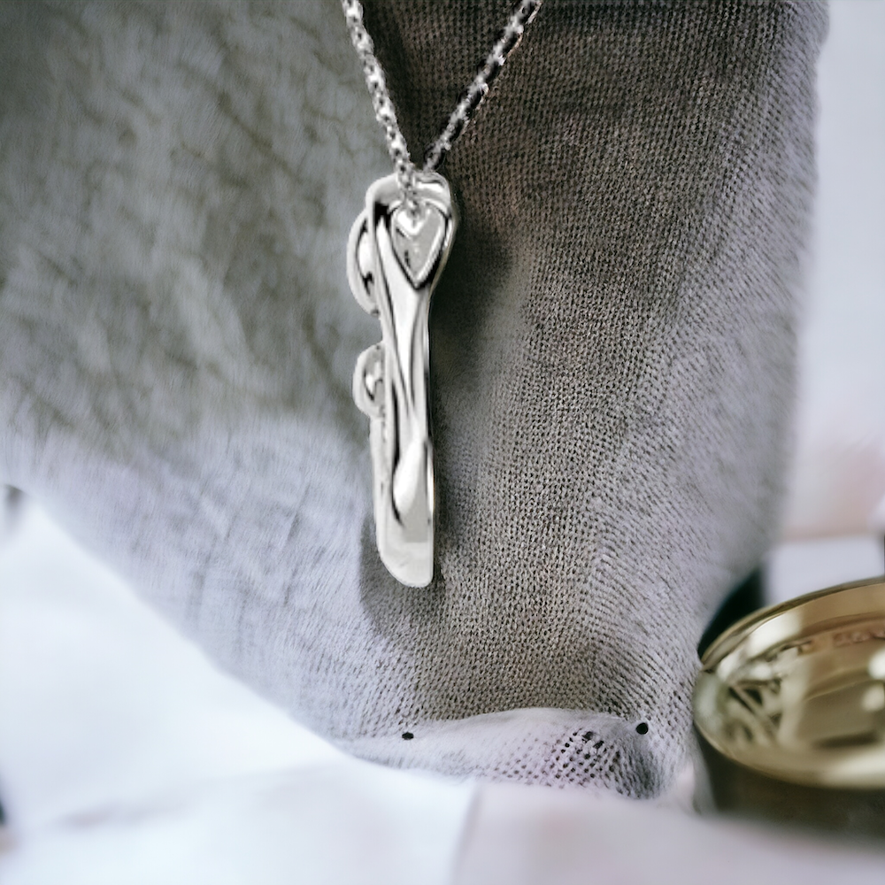 Side view of the family embrace necklace with a gleaming surface, the silver pendant's curves represent the nurturing arms of a parent.