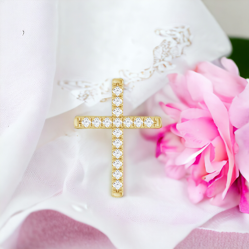 Gold diamond cross pendant laying on a satin fabric, with pink flowers enhancing its luxurious and devout design.