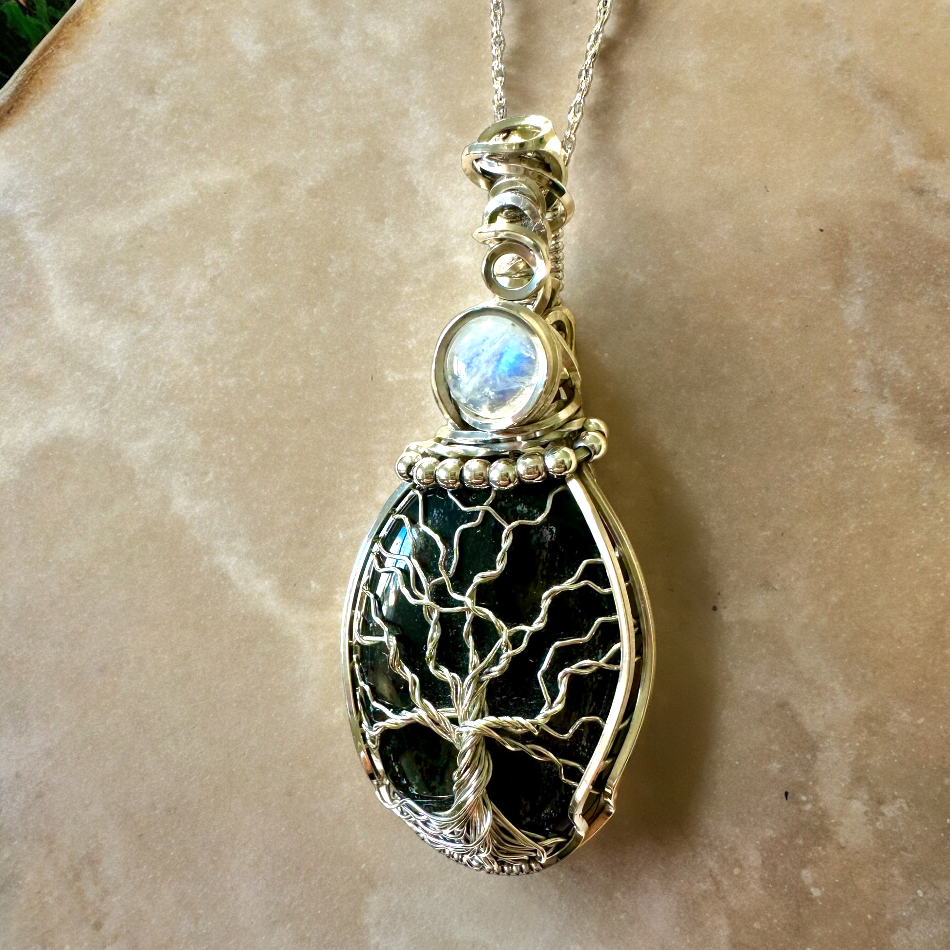 Detailed view of the Lunar Reflections Tree of Life Necklace showing the intricate silver tree branches and moonstone detail.