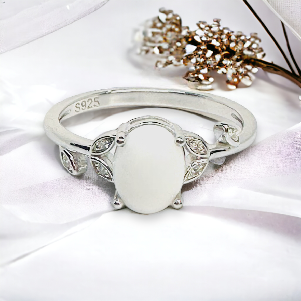 Close-up of the Flora Petite Floral Breastmilk Ring in Silver, showcasing a white breastmilk stone, surrounded by cz leaves, a symbol of nurturing love and the bond between mother and child.