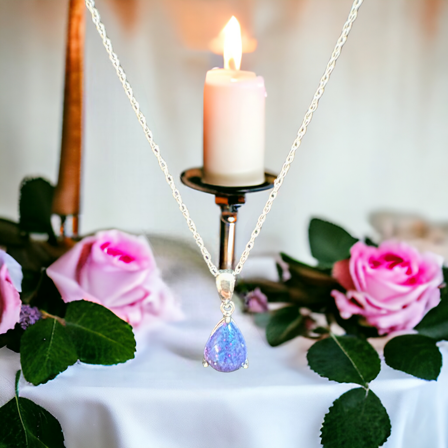 Detailed view of the Whisper Drop sterling silver necklace, displaying a vibrant blue mica and sparkle cremation stone, reflecting the beauty and depth of cherished memories.