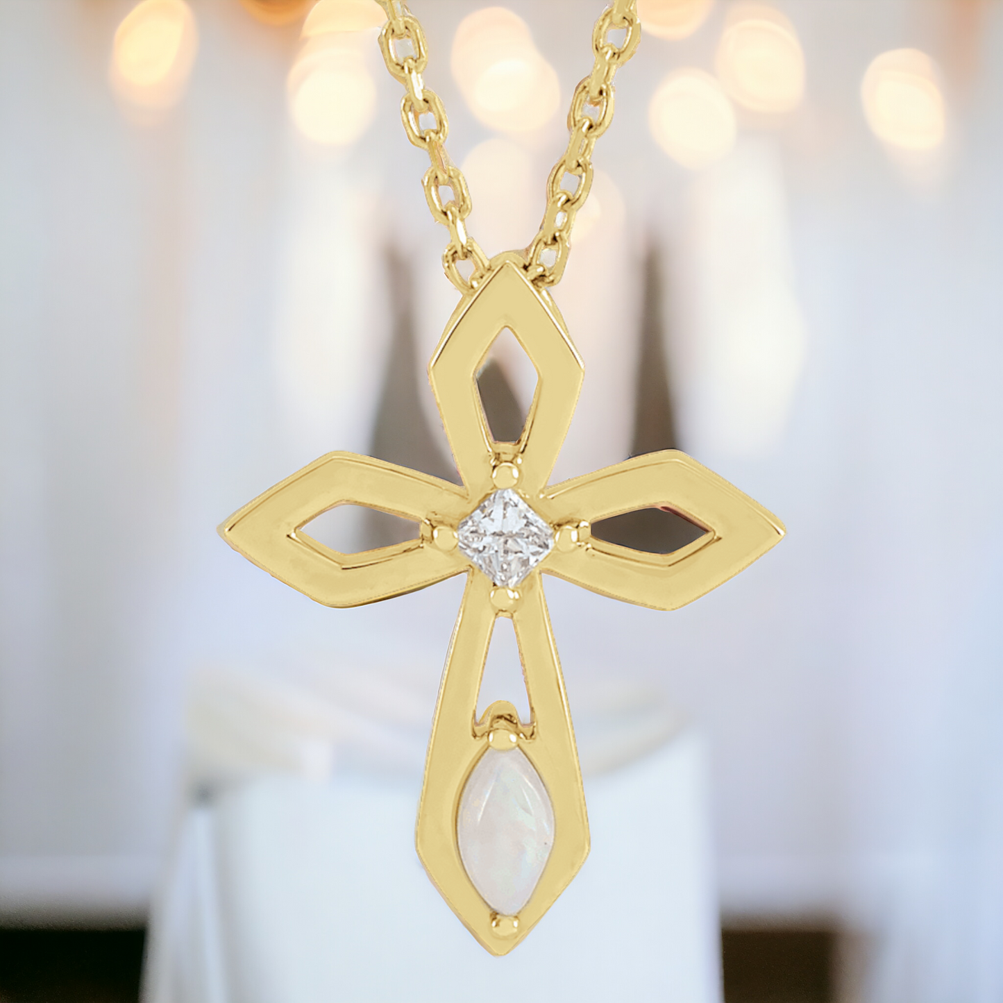 14k gold cross necklace featuring a unique open design with a central diamond and an elongated marquise-shaped opal at the bottom. The intricate craftsmanship and elegant appearance make it a stunning piece for any occasion.