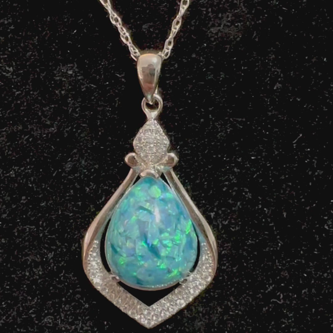 Video showing close-up and all angles of the Crystal Drop sterling silver necklace with a blue crushed opal cremation stone on a black display, emphasizing the piece's beauty and the depth of its meaning.