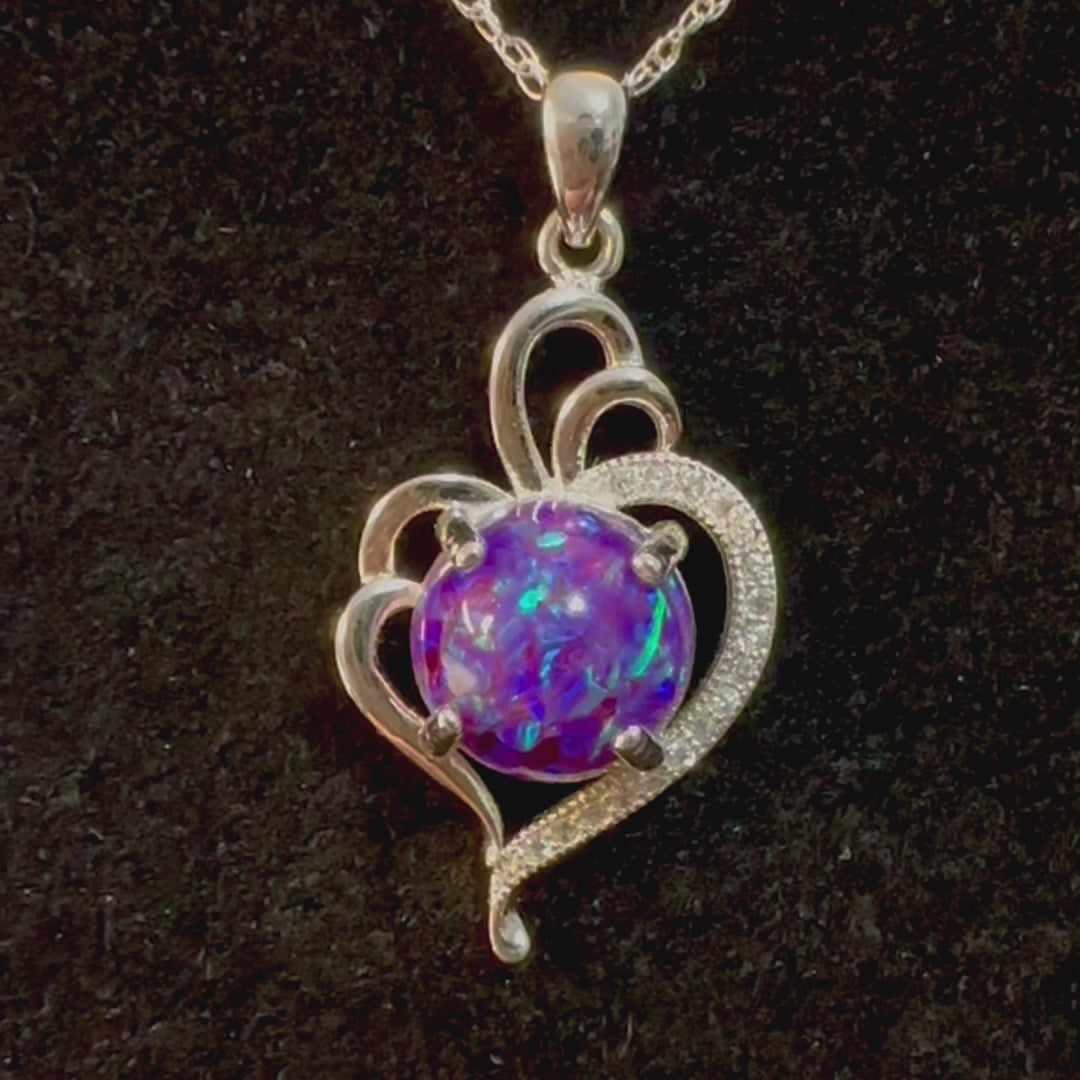 Video showcasing the Radiant Heart pendant with a sparkly purple crushed opal cremation stone in sterling silver, rotating to reveal all angles, highlighting the pendant's luminous beauty and heartfelt significance.