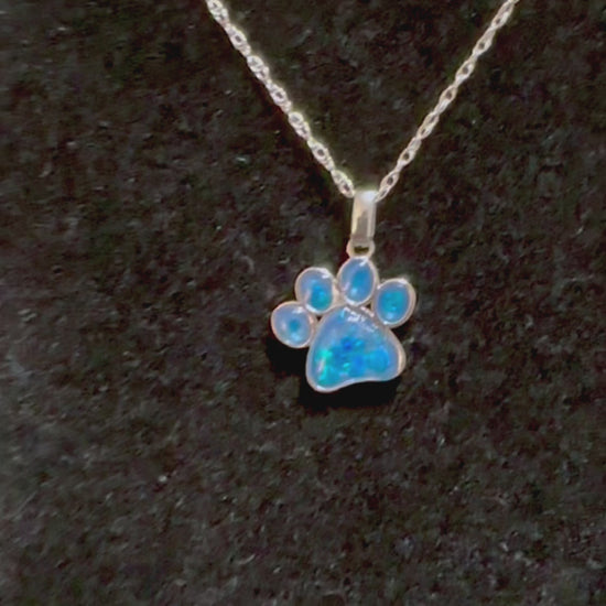 Video of Angel Paws sterling silver necklace with blue opal cremation stones  on a display, demonstrating all angles of the pet memorial pendant.