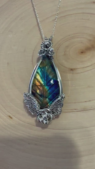 Video displaying the Enchanted Forest Labradorite Necklace, showing the shimmering labradorite leaf in motion, enhancing the vivid colors and detailed silver setting.