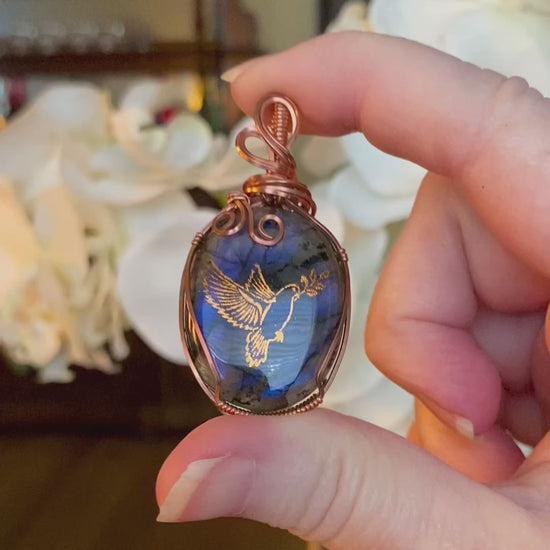 Video showcasing the front and back of the Forever necklace with a beautiful blue Labradorite gemstone and copper peace dove design.